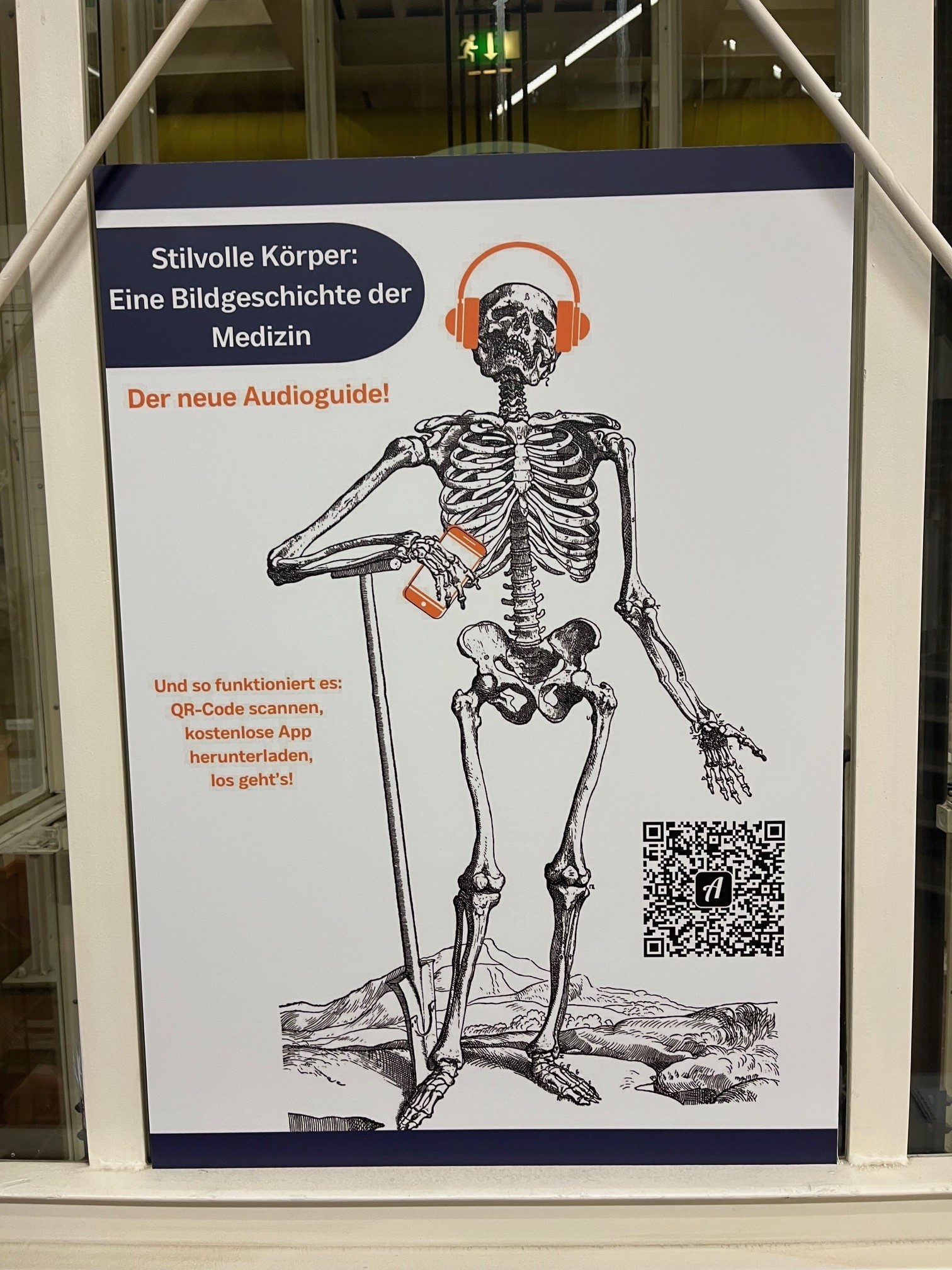 Plakat zur Ausstellung "Stilvolle Körper: Eine Bildgeschichte der Medizin." QR-Code für den begleitenden Audioguide. Abgebildet ist ein Skelett mit Kopfhörern das einem Audioguide zuhört.