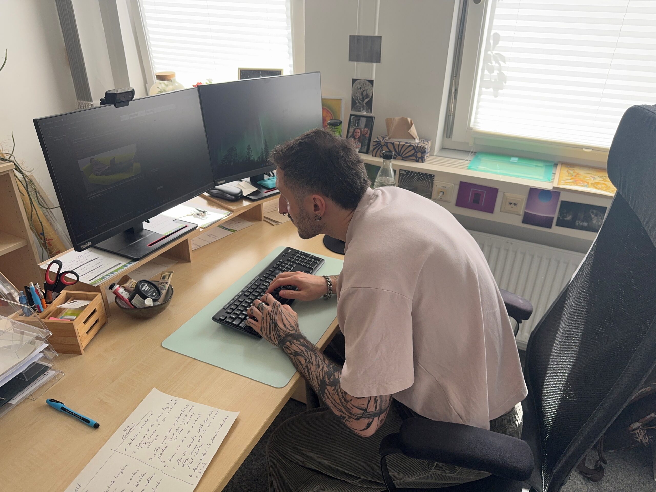 Mann sitzt sehr krumm vor einem Computer und schreibt.